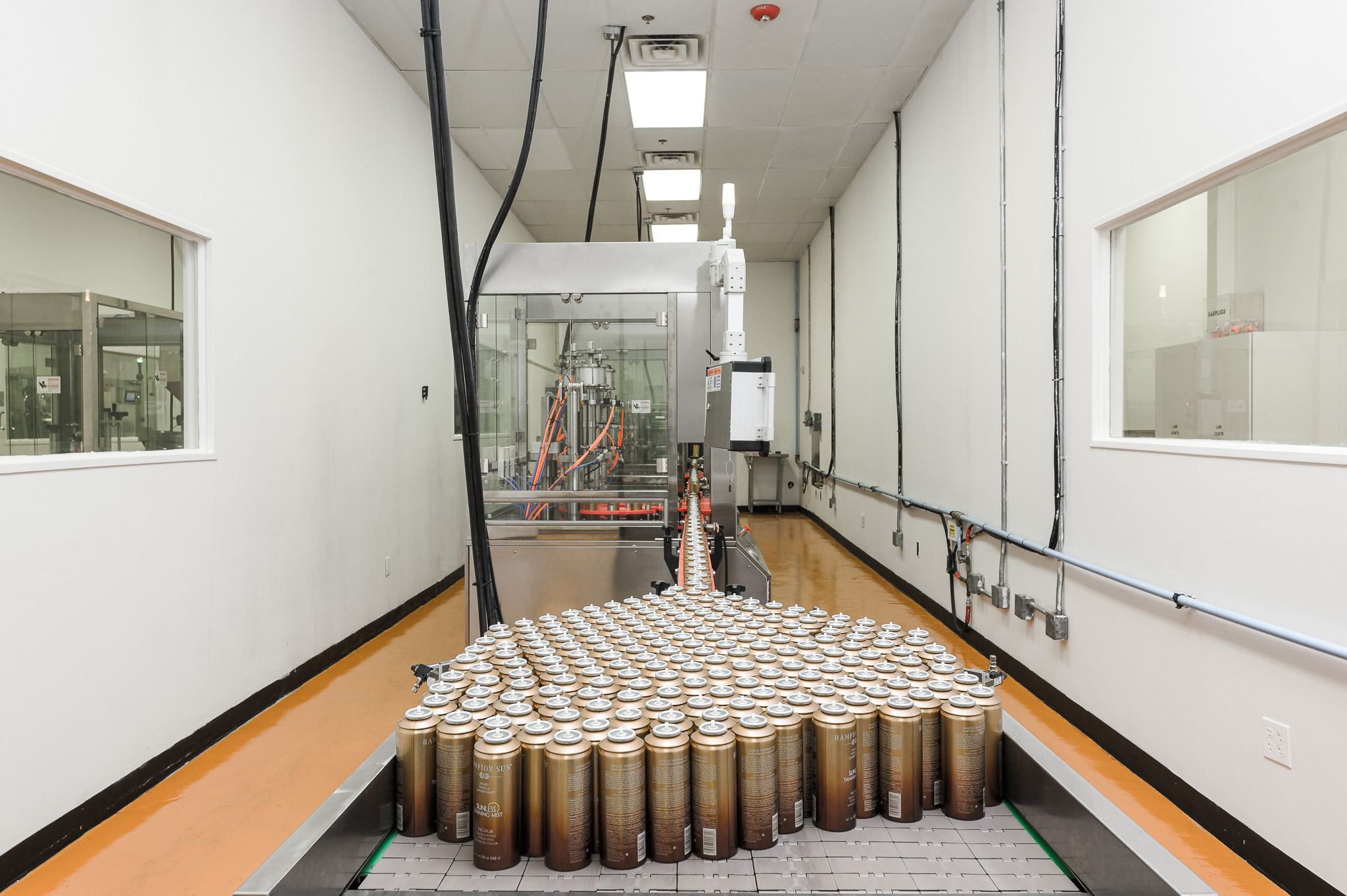 Gold aerosol cans staged on the bag-on-valve and aerosol filling line