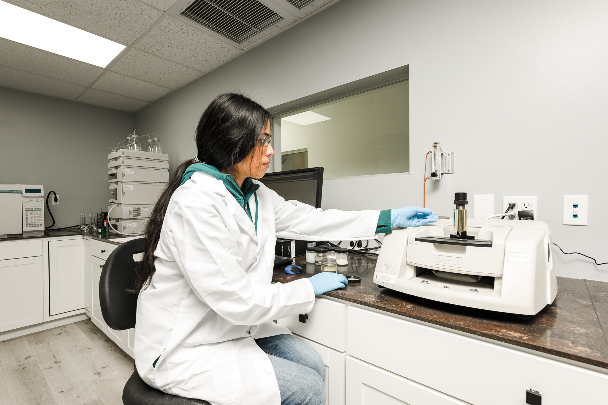 Scientist operating an FTIR spectrometer in the analytical lab