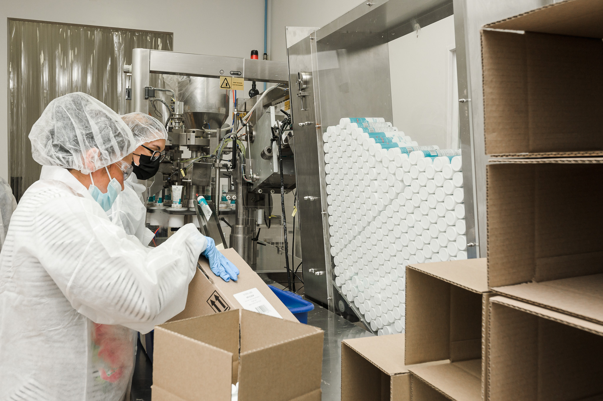 Workers cartoning finished units on the packaging line
